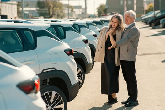 An elderly Caucasian man gives a new car to his beloved woman