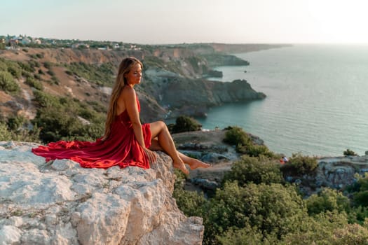 Woman sunset sea red dress, portrait happy beautiful sensual woman in a red long dress posing above the sea on sunset