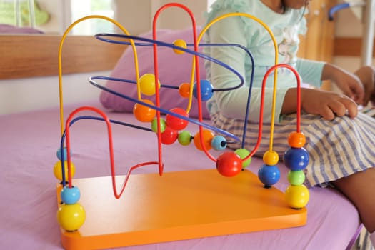 preschool child playing with wooden toy.