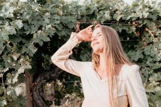 Woman at autumn winery. Portrait of happy woman holding glass of wine and enjoying in vineyard. Elegant young lady in hat toasting with wineglass smiling cheerfully enjoying her stay at vineyard