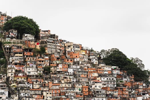 Vibrant hillside favela with colorful homes showcases the sharp disparity between local poverty and surrounding city wealth.