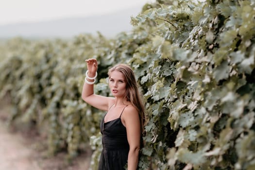 Woman at autumn winery. Portrait of happy woman holding glass of wine and enjoying in vineyard. Elegant young lady in hat toasting with wineglass smiling cheerfully enjoying her stay at vineyard