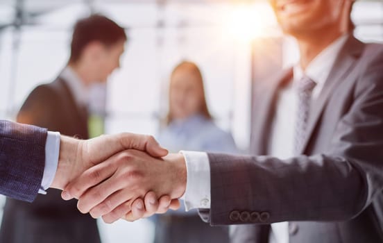 composite of Business people shaking hands against blurred background