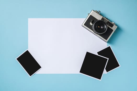 Vintage photo camera and empty photo frames on blue background. Travel moment concept