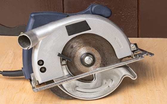 A small electric circular saw on a workbench.