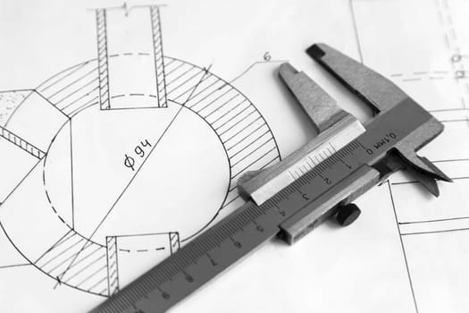 On the detail drawing lies measuring tool Vernier caliper. Black and white image.