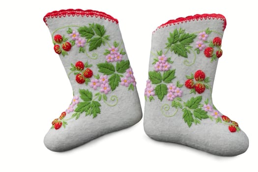 Beautiful warm shoes made of felt, decorated with embroidery. Presented on a white background.
