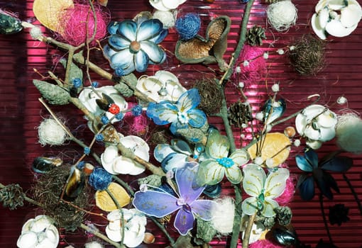 A decorative panel located artificial flowers and butterflies made of different materials.