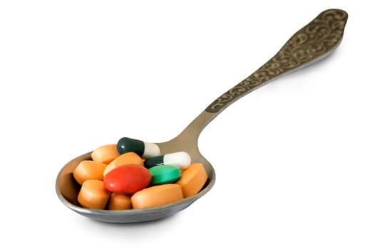 In a metal spoon different medications in pill form. Presented on a white background.