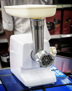 Modern electric meat grinder is sold in the hardware store.