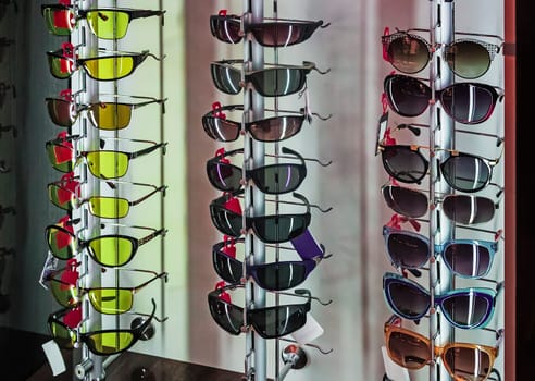 On the stand in the store window features a variety of models of modern sunglasses.