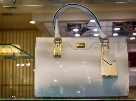 The storefront presents for sale a beautiful white leather womens bag.