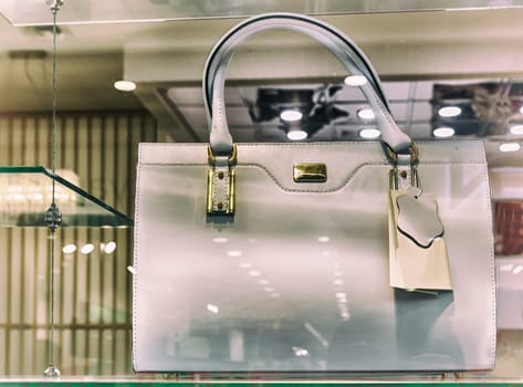 The storefront presents for sale a beautiful white leather womens bag.