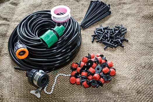 A set of tools for drip irrigation of plants and garden: hose, sprinklers, joints, hose holders.