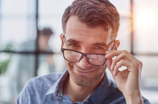 IT guy adjusting glasses in a modern new office