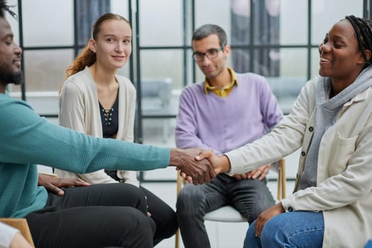 young people shaking hands in a circle of like-minded people