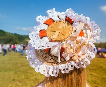 On the girl's head is an original hat, decorated with lace and ribbons.