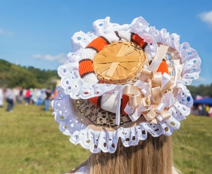 On the girl's head is an original hat, decorated with lace and ribbons.