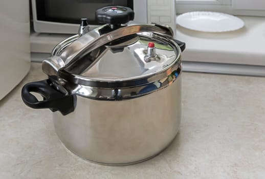 Spacious pan with convenient lid for fast cooking with high pressure steam.