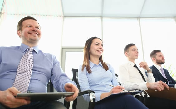 Portrait of smart people sitting in big modern building and talking with witty boss about important business contract that determine future of colossal corporation. Company meeting concept