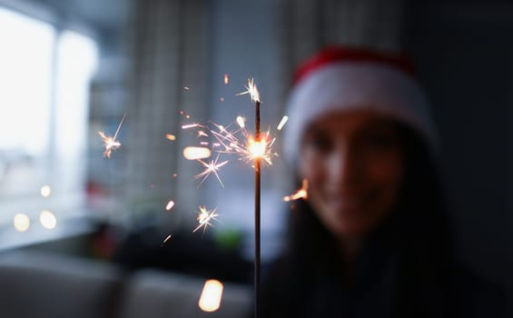 Woman hold sparklers in hand closeup. Xmas dark bacground concept