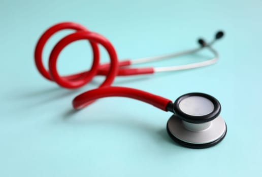 Red doctor stethoscope on blue modern background close-up. Medical insurance concept