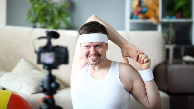 Man Vlogger Doing Exercise for Hands Portrait. Happy Sportsman Recording Fitness Training on Digital Camera for Sport Vlog. Bearded Male Shoot Gymnastics Video on Camcorder Close-up Photography