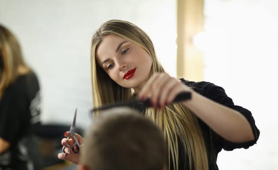 Young Woman Barber Cutting Client Hair in Salon. Hairdresser Holding Scissors and Hairbrush. Beautiful Hairstylist Combing Man. Beautician Styling Male Haircut in Beauty Salon. Professional Barbershop