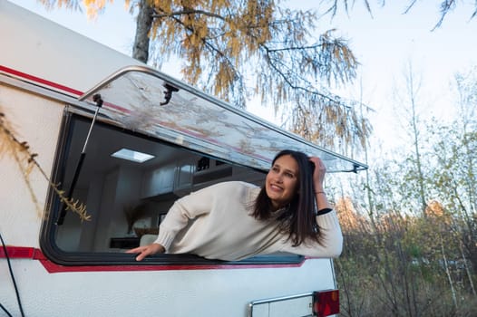 Caucasian woman peeking out of camper window