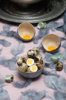 quail eggs in ceramic vases, gray feathers on the table, Easter still life with dietary eggs, diet and antioxidants, dark key and shallow depth of field, high quality photo