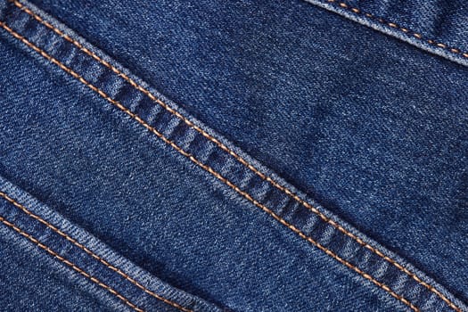 Seams on jeans close-up. Stitching on denim. Fabric texture. Blue jeans background and texture. Close up of blue jeans background. Denim texture in high-resolution.