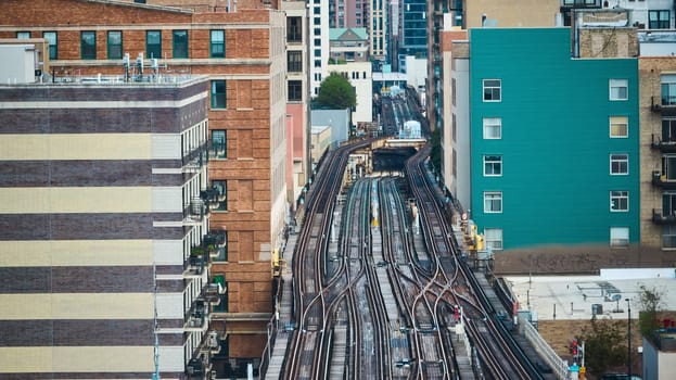 Image of Empty train tracks in city, travel, transportation with aerial of buildings lining railroad, Chicago