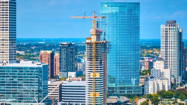 Sunny 2023 aerial view of vibrant Milwaukee showcasing ongoing skyscraper construction and Northwestern Mutual building amid urban development