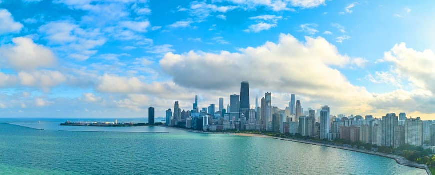 2023 Aerial panorama of Chicago's skyscraper-laden skyline overlooking tranquil Lake Michigan, captured by drone