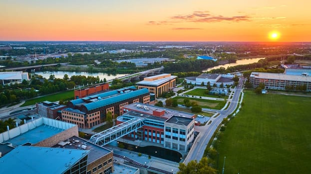 Aerial View of Indianapolis Urban Landscape at Sunset, Showcasing Modern Architecture, Green Spaces, and Calm River