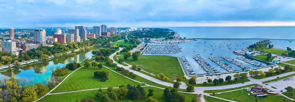 Early morning aerial panorama of Milwaukee, Wisconsin showcasing a serene urban skyline, a bustling marina, and tranquil Lake Michigan
