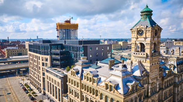 Historic clock tower stands proudly in Milwaukee, Wisconsin, showcasing a blend of architectural eras under a clear blue sky, captured from an aerial view.