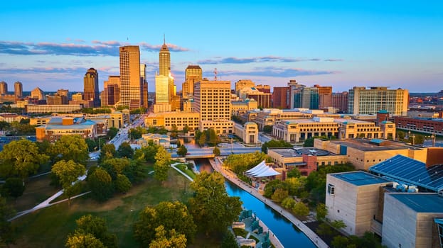 Golden Hour Over Indianapolis: Aerial View Featuring Urban Park, High-Rises and Canal