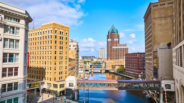 Vibrant 2023 Milwaukee cityscape showcasing architectural diversity, historic Riverside signage, and bustling urban river, captured from a high vantage point with a DJI Mavic 3 drone.