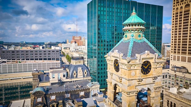 Daytime aerial view of Milwaukee, showcasing the architectural contrast of a historic clock tower and modern skyscraper, captured by a DJI Mavic 3 drone