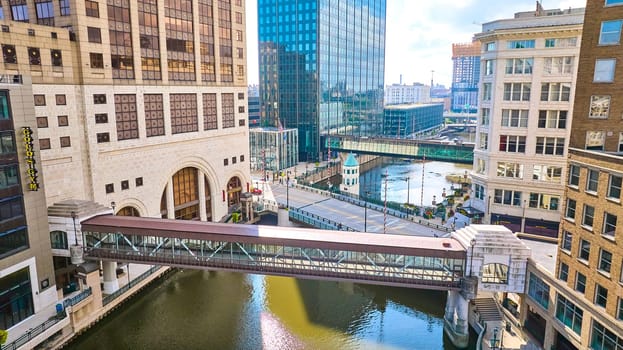 Aerial View of Modern Pedestrian Bridge Spanning River in Diverse Architectural Milwaukee Cityscape, 2023