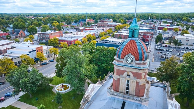 Aerial view of historic Elkhart County Courthouse with red-tiled dome in charming downtown Goshen, Indiana, captured by DJI Mavic 3 drone