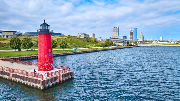 Vibrant aerial view of Milwaukee Pierhead Lighthouse on Lake Michigan, symbolizing maritime safety against a backdrop of urban growth, 2023.