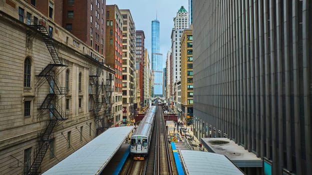 Image of Train traveling toward Trump Tower, tourism with downtown skyscraper buildings, Chicago aerial