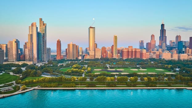 Image of Aerial over Lake Michigan with skyline view of Chicago coastline and skyscrapers at sunrise