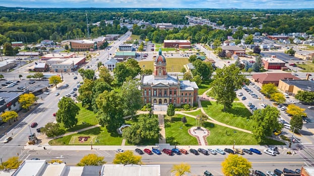 Vibrant aerial view of the historic Elkhart County Courthouse, showcasing the charm of small-town Goshen, Indiana and illustrating the harmony of nature and urban life