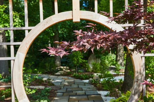 Serene garden pathway with vibrant Japanese maple leaves, through a wooden archway at the Botanic Gardens, Elkhart, Indiana, 2023