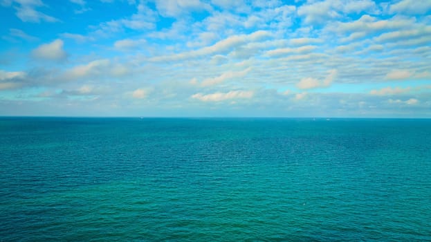Image of Blue sky with white clouds over blue green water aerial of Lake Michigan, dream, inspiration