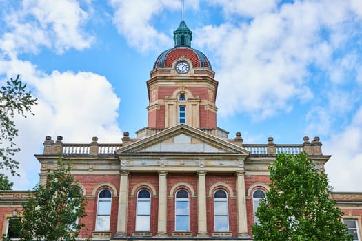Image of Elkhart County courthouse on blue sky day with fluffy white clouds, law and order, summer day, IN