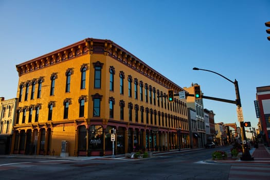 Golden hour illuminating Patterson Block's ornate architecture and inviting Indiana street scene, marrying historical charm with vibrant urban life.